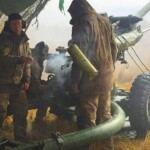 A gunner unloading the hot spent cartridge and tossing it away from the gun a moment after the gun has fired a shell at a target area about 10 km distant from the gun.